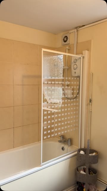 A clean bath with glass shower screen