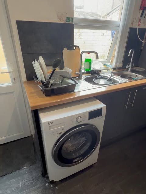 A tidy kitchen sink area and washing machine